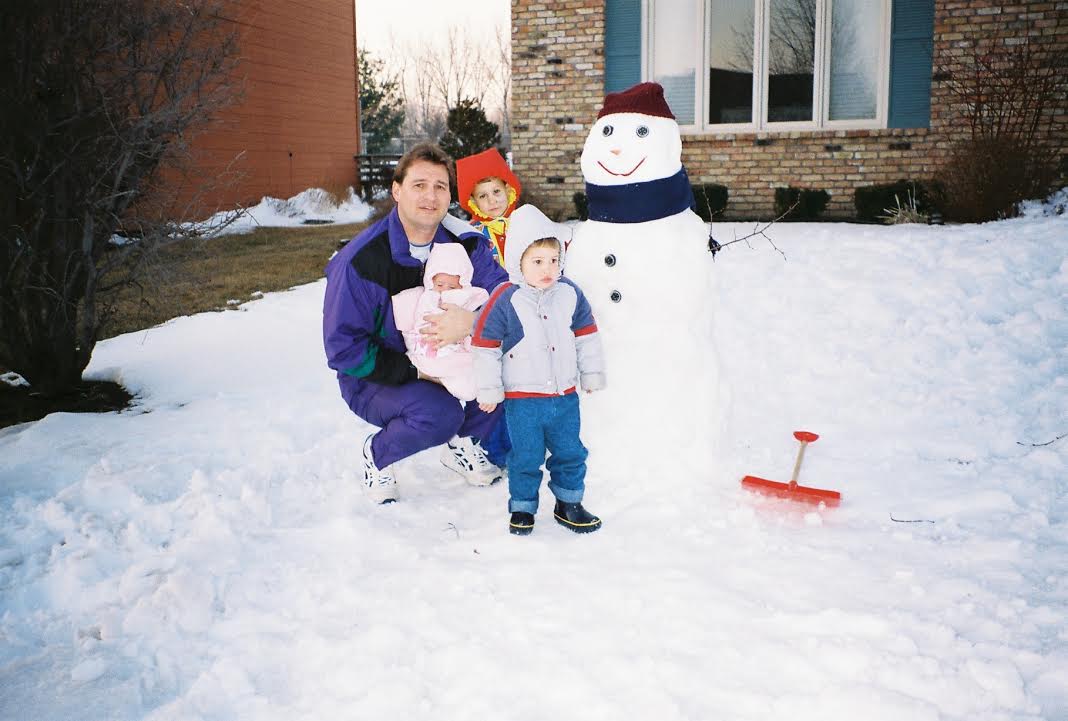 Joslin with her dad and brothers building a snowman